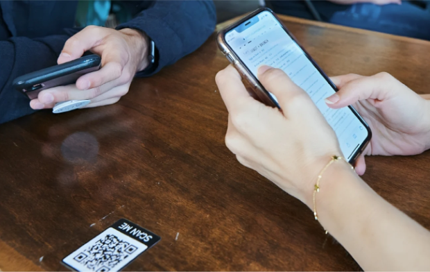 Two guests using phones to order at a restaurant table